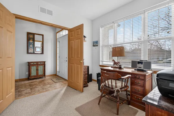 a view of a workspace with furniture and a window