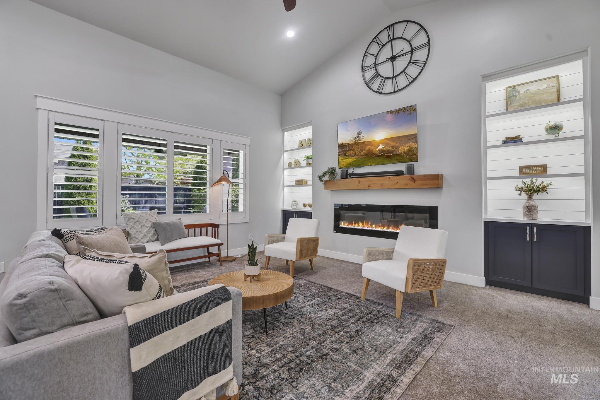 1937 Tamarack Loop Twin Falls, ID 83301 - Photo 9 of 50 Living area featuring vaulted ceilings, plantation shutters, a linear fireplace with wood-finish mantel, and built-in shelving with cabinetry
