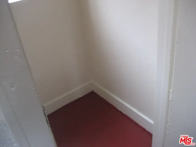 a kitchen with white cabinets and a stove with wooden floor