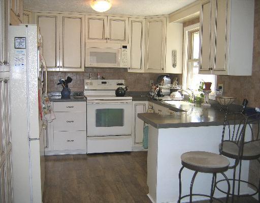 10 Wolf Road Bourne, MA 02532 - Photo 4 of 9 a kitchen with granite countertop white cabinets and white appliances