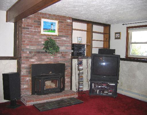 10 Wolf Road Bourne, MA 02532 - Photo 7 of 9 a living room with furniture a flat screen tv and a fireplace