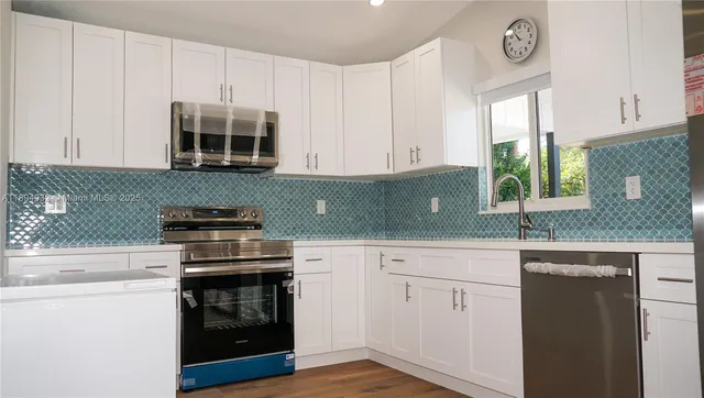 a kitchen with stainless steel appliances granite countertop a sink a stove and a microwave