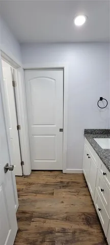 an empty room with wooden floor and cabinet