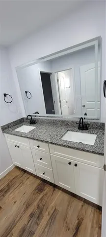 a bathroom with a granite countertop sink and a mirror