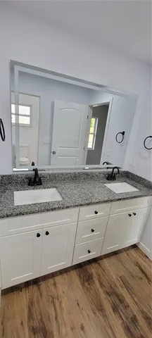 a bathroom with a granite countertop sink and mirror