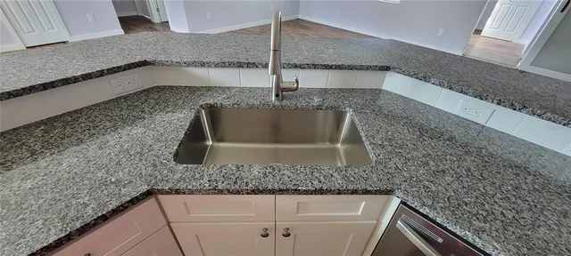 a kitchen with kitchen island granite countertop a sink and granite counter tops