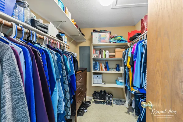 a view of walk in closet with clothes and shoes