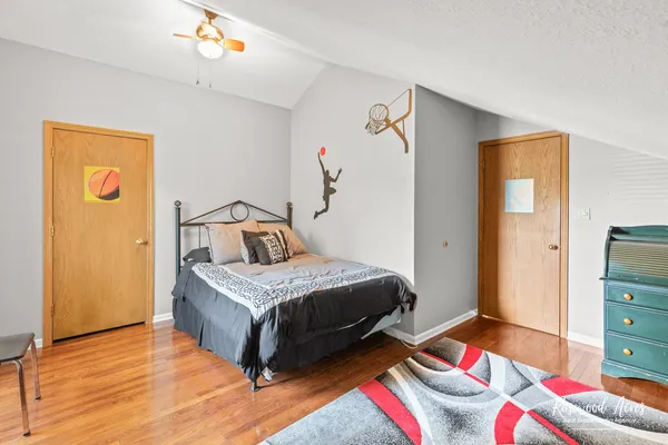 a bedroom with a bed and wooden floor