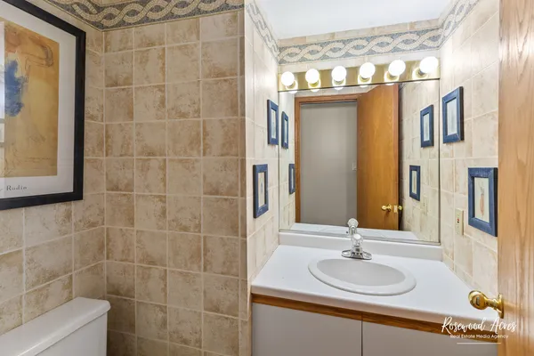 a bathroom with a sink a toilet and a mirror