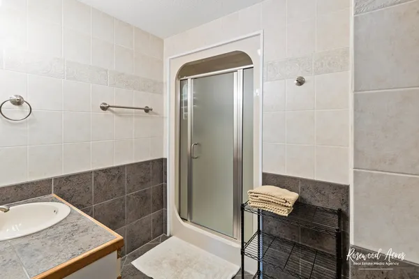 a bathroom with a granite countertop sink a mirror and a shower
