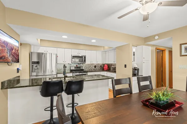 a living room with stainless steel appliances kitchen island granite countertop furniture and a potted plant