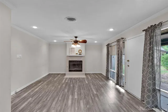 a view of empty room with wooden floor and window