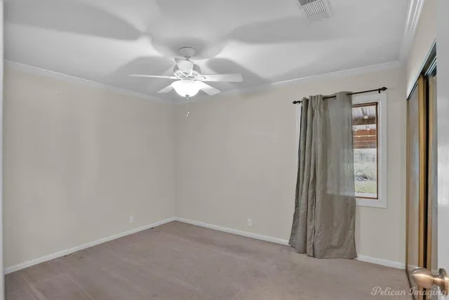 an empty room with windows and fan