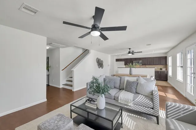 a living room with furniture and a ceiling fan