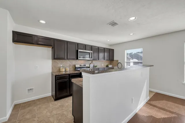 a kitchen with stainless steel appliances granite countertop a refrigerator sink and stove
