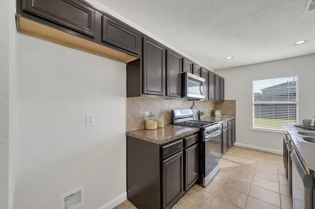a kitchen with stainless steel appliances granite countertop a sink stove and cabinets