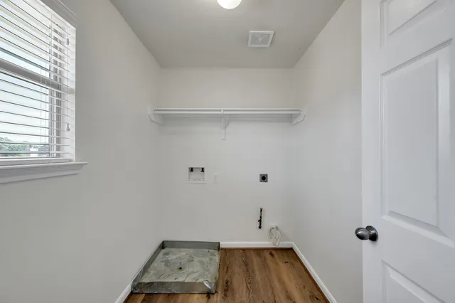 a small space with wooden floor and a window