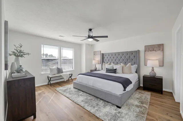 a bedroom with a bed and wooden floor