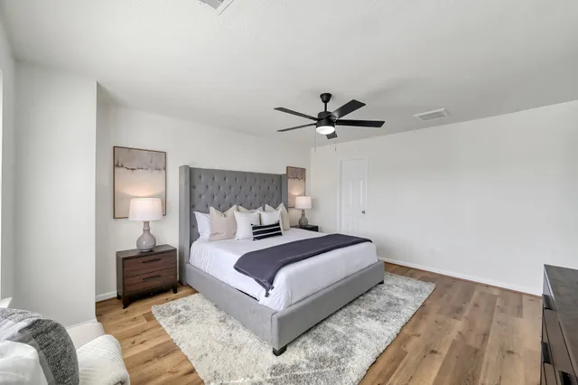 a bedroom with a large bed and a lamp