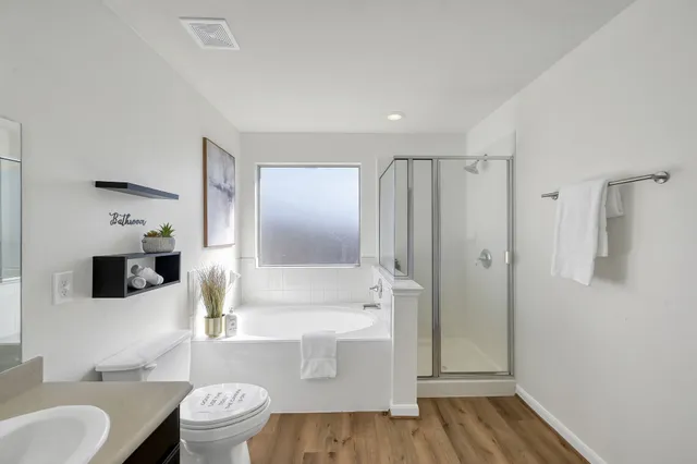 a bathroom with a tub toilet sink and mirror