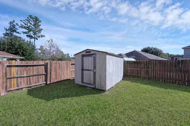 a view of a backyard with barn plants and wooden fence