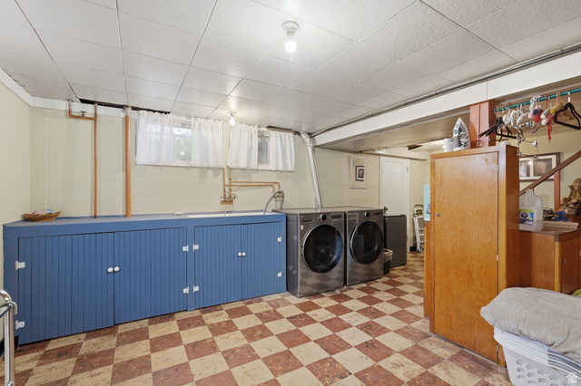 7576 South Jefferson Street Midvale, UT 84047 - Photo 29 of 53 Laundry area featuring checkerboard flooring, a utility sink, and built-in blue cabinetry with white hardware