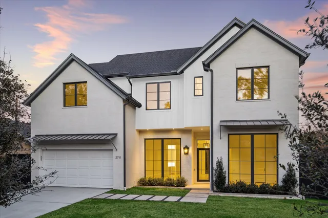 a view of a white house with large windows and a yard