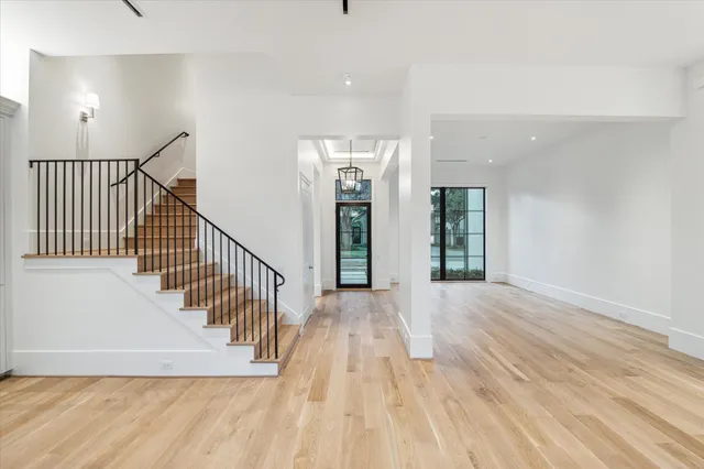 a view of a hallway with wooden floor and windows