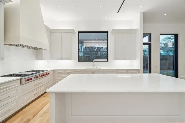 a view of a kitchen with kitchen island a sink dishwasher and a stove with wooden floor