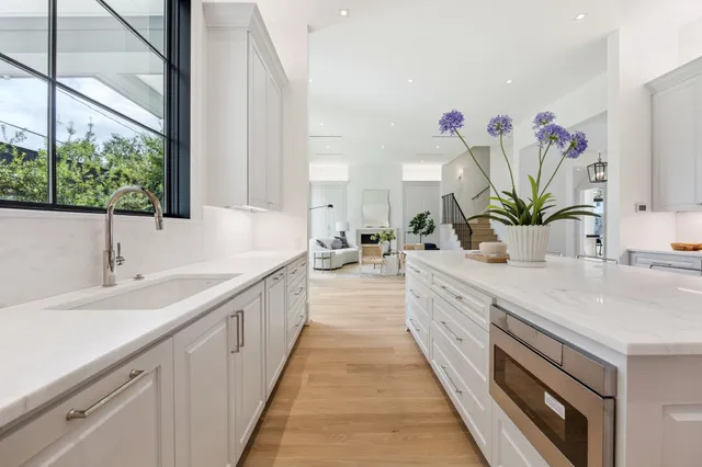 a large white kitchen with a lot of white cabinets