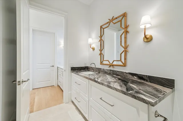 a bathroom with a granite countertop sink and a mirror