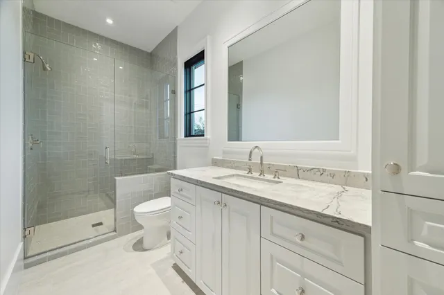 a bathroom with a granite countertop sink toilet and shower