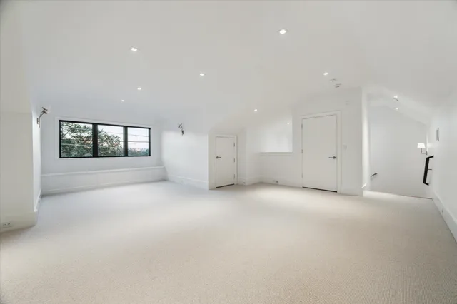 an empty room with a window and fireplace