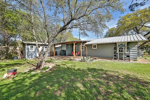 a view of a house with backyard and a tree
