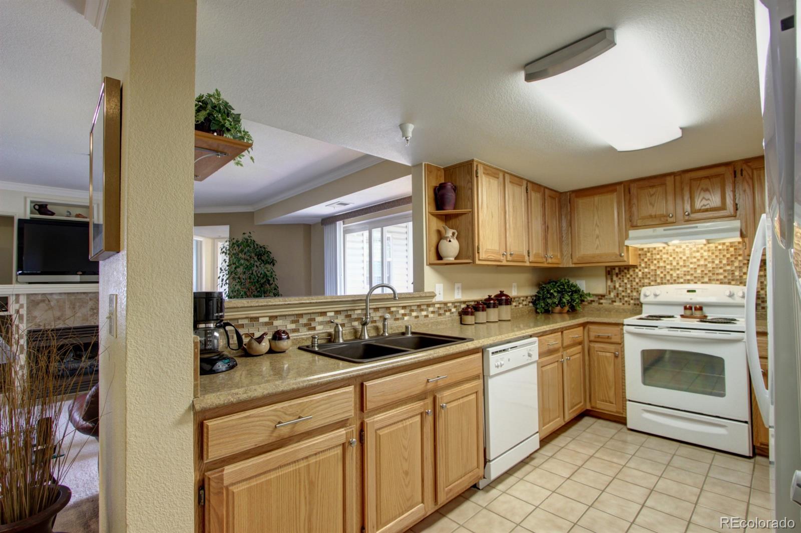 12208 West Dorado Place, Unit 207 Littleton, CO 80127 - Photo 1 of 1 a kitchen with a stove a sink and a refrigerator