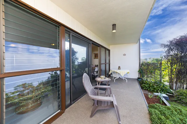 a balcony with chairs and with potted plants