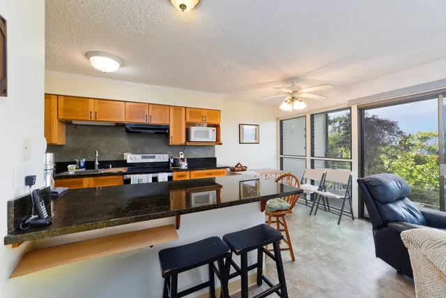 a dining room with stainless steel appliances a couch and a large window