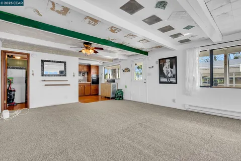 a kitchen with stainless steel appliances granite countertop a refrigerator a stove and a sink with large window