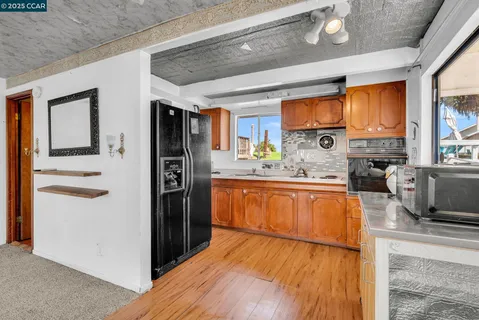 a kitchen with stainless steel appliances kitchen island a refrigerator and a sink