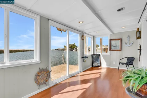 a living room with furniture a wooden floor and a potted plant