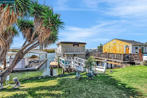 a view of a house with a big yard and large trees
