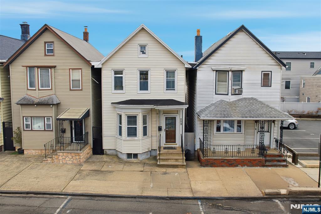 a view of a white house with large windows next to a road