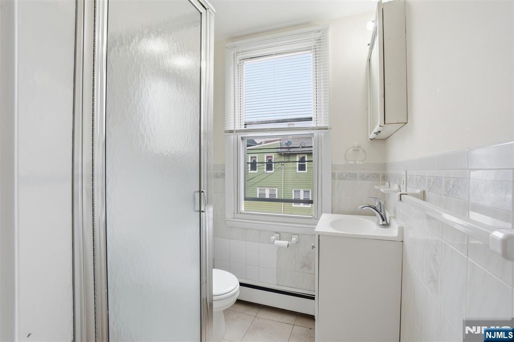 209 Hamilton Street Harrison, NJ 07029 - Photo 15 of 26 a bathroom with a sink a toilet and a mirror
