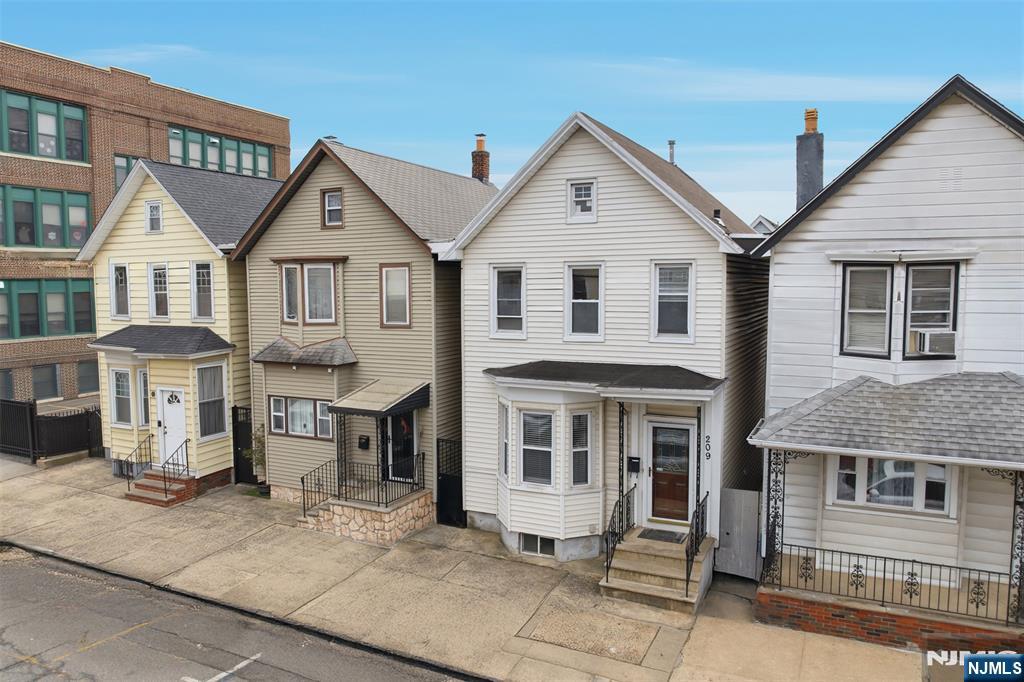 209 Hamilton Street Harrison, NJ 07029 - Photo 2 of 26 a front view of a house with a porch