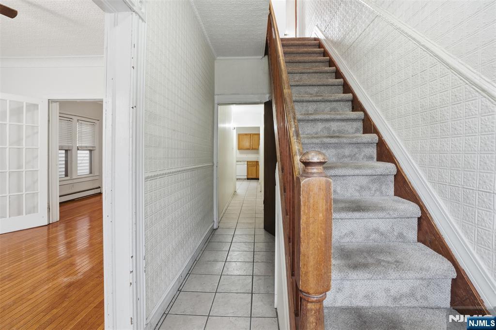 209 Hamilton Street Harrison, NJ 07029 - Photo 5 of 26 a view of a hallway with wooden floor and staircase