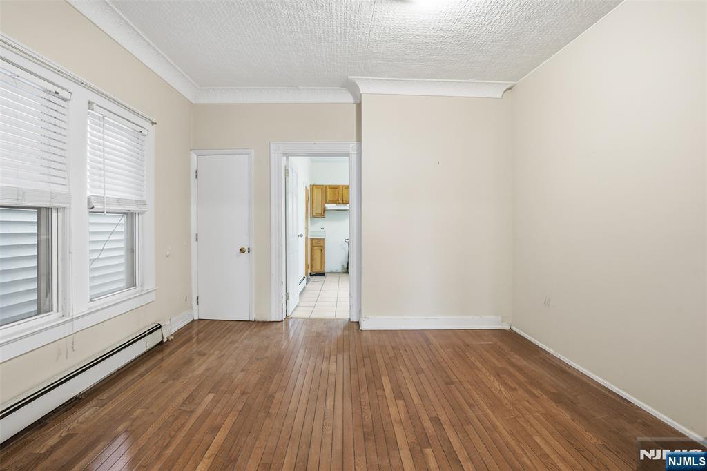 209 Hamilton Street Harrison, NJ 07029 - Photo 7 of 26 wooden floor in an empty room with a window