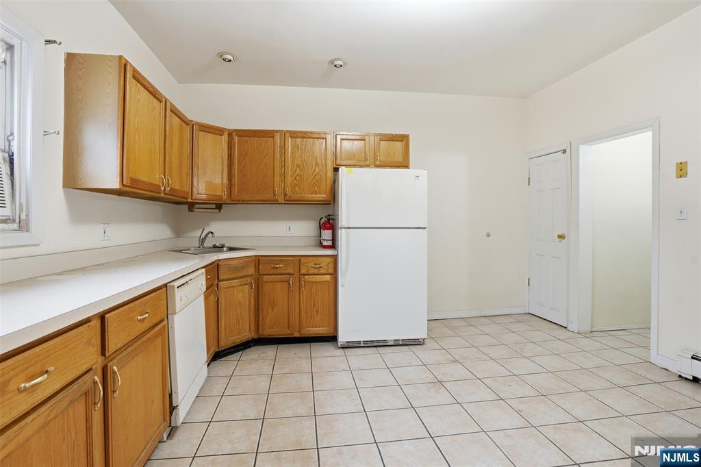 209 Hamilton Street Harrison, NJ 07029 - Photo 9 of 26 a kitchen with a sink a refrigerator and cabinets
