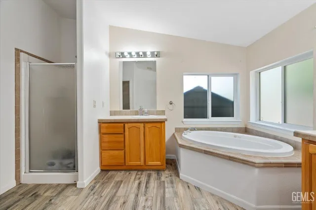 a bathroom with a tub a sink and a mirror