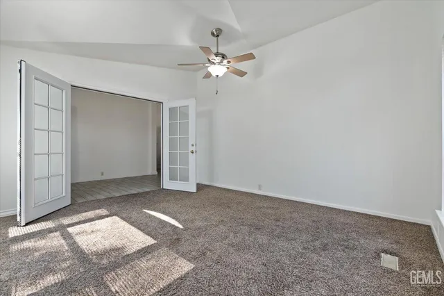an empty room with closet and a ceiling fan