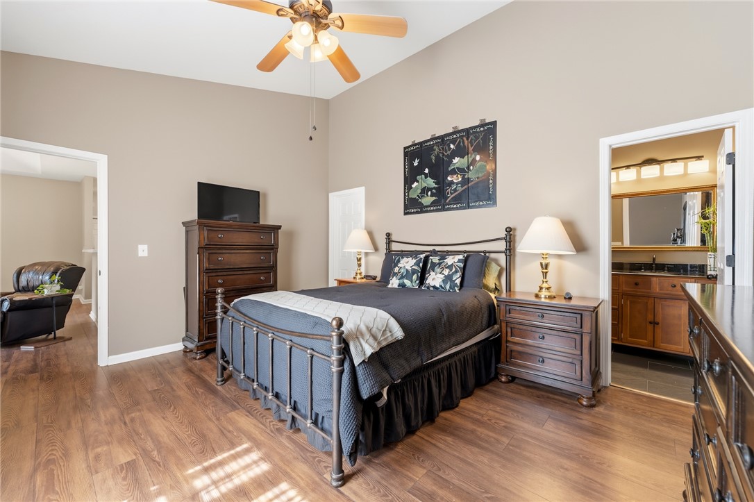 160 Wexford Drive, Unit 206 Anderson, SC 29621 - Photo 19 of 31 A well-lit primary bedroom features LVP flooring and a ceiling fan.